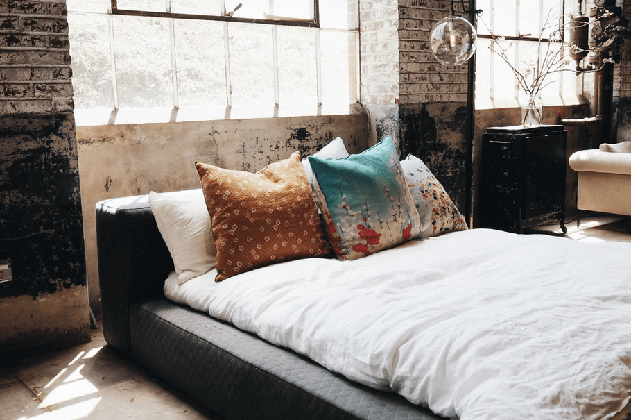 styl industrialny w sypialni z betonową ścianą