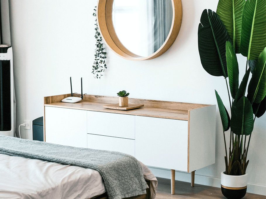 łóżko, komoda i lustro w sypialni w stylu skandynawskim